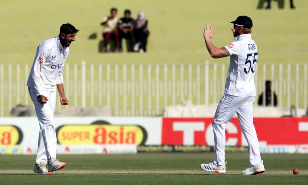 Two England cricketers celebrate during a Test match, one appealing after a delivery as the other supports from the field.