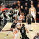 Intense moment in a basketball game with an Atlanta Hawks player scoring a layup against the Milwaukee Bucks.