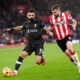 A Liverpool player competes for the ball with a Southampton player during a Premier League match.