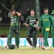 Pakistan and South Africa cricket players walking off the field after a match, showcasing a moment of sportsmanship and competition.