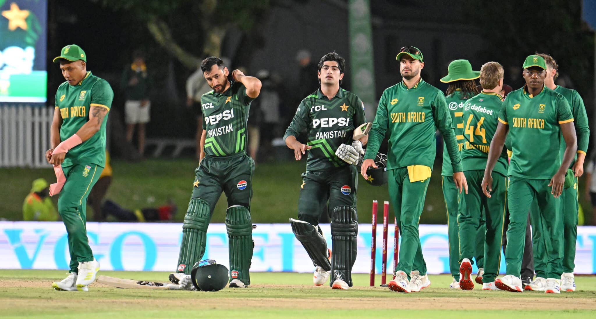 Pakistan and South Africa cricket players walking off the field after a match, showcasing a moment of sportsmanship and competition.